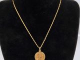 un collier en or avec une pièce de monnaie sur le cou d'un mannequin