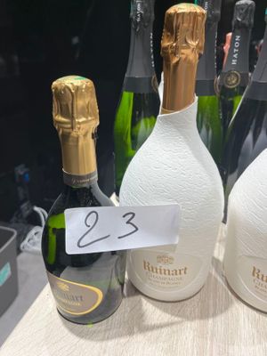 plusieurs bouteilles de champagne posées sur une table, avec une étiquette indiquant le prix
