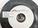 a black and white disc on a table next to a red and white piece of paper