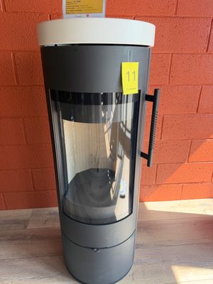 une machine posée à même le sol devant un mur de briques