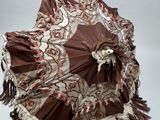 un parapluie marron et blanc orné de franges