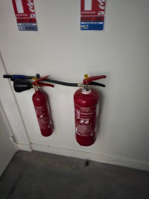 deux extincteurs accrochés au mur l'un à côté de l'autre