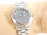 a silver watch on the wrist of a woman