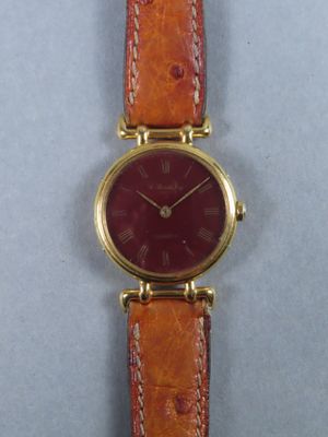 un gros plan d'une montre-bracelet au cadran rouge