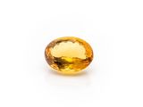 a yellow sapphire stone on a white background