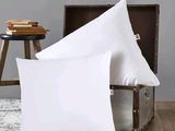 une paire de coussins blancs posés sur une table en bois