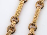 pair of gold tone bracelets with engraved design on each side