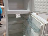 a white refrigerator with its door open in a warehouse