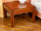 une petite table sur laquelle se trouve une lampe, dans un coin de la pièce