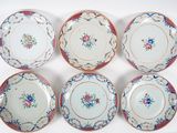 six assiettes ornées de motifs floraux sont disposées sur un fond blanc