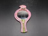 un miroir rose orné d'un oiseau, posé sur un fond noir