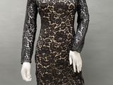 a mannequin wearing a black lace dress with long sleeves