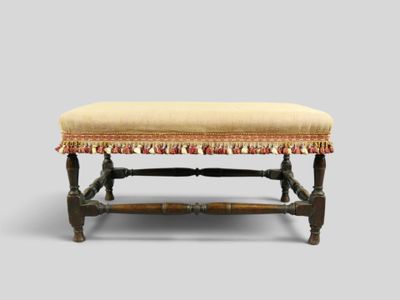 un vieux banc en bois avec un coussin rembourré beige