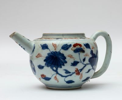 une théière bleue et blanche décorée de fleurs et de feuilles