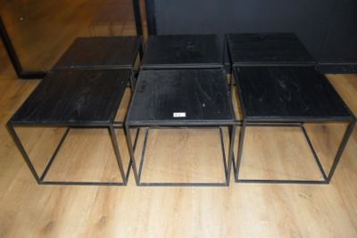 three black tables sitting on top of a wooden floor next to each other