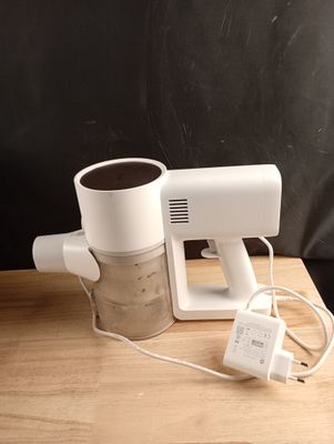 un mixeur posé sur une table, avec une tasse de café à côté