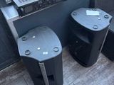 two speakers sitting next to each other on the floor