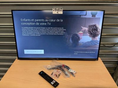 une télévision posée sur une table, avec une télécommande
