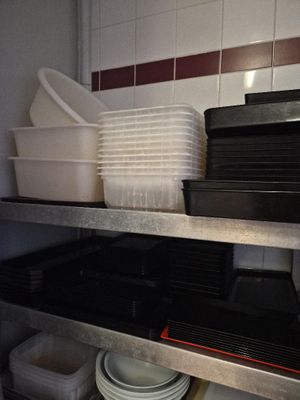 de nombreuses assiettes et casseroles empilées sur une étagère dans une cuisine