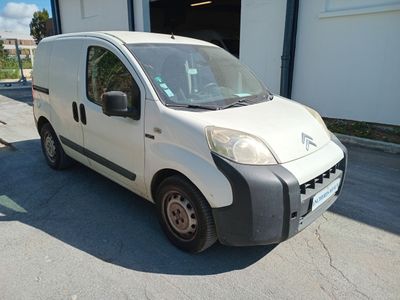 a small white van parked in front of a building
