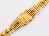 a close up of a gold wrist watch on a white surface