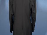 a black suit on a mannequin stand against a blue background