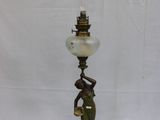 une lampe à l'ancienne représentant une femme tenant un abat-jour en verre