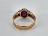 a close up of a gold ring with a ruby stone