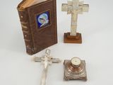 un livre, une croix et une bougie posés sur une table