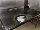 a dirty counter in a commercial kitchen with a lot of dirty stuff on it