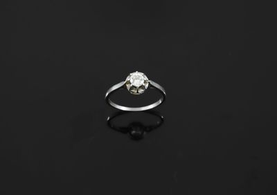 a single stone diamond ring on a black surface