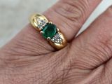 une image représentant la main d'une femme portant une bague en or sertie de trois émeraudes