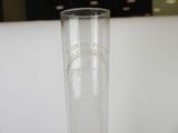 a tall glass with a small amount of water in it