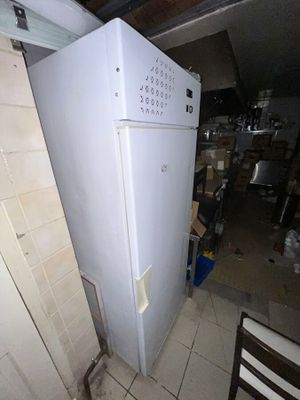 un réfrigérateur blanc au milieu d'une cuisine sale
