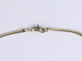 a close up of a gold chain bracelet on a white surface