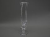 un vase en verre transparent posé sur une surface grise
