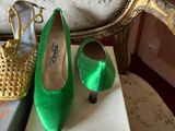 pair of green shoes sitting on top of a box next to a gold purse