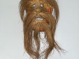 une photo d'un masque en osier accroché à un mur