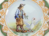 a plate with a picture of a man and a goose