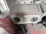 a washing machine sitting on top of a stack of dryers