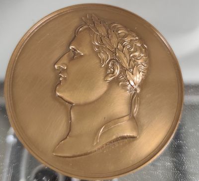 une image représentant une médaille d'or sur laquelle figure le visage d'un homme