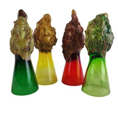 quatre vases en verre de couleurs différentes, surmontés d'une tête de lion