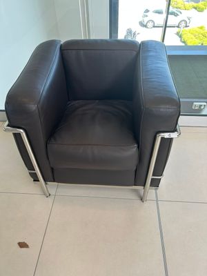 un fauteuil en cuir noir placé devant une porte vitrée