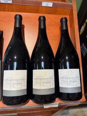trois bouteilles de vin sont posées sur une étagère dans un magasin de vins