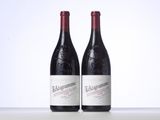 two bottles of red wine sitting next to each other on a table