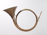 an old brass french horn is hanging from the ceiling