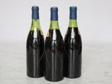 three bottles of wine are lined up on a marble surface