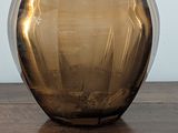 a brown glass bowl sitting on a wooden table