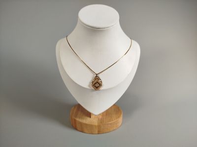 un mannequin blanc portant un collier en or