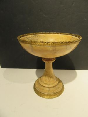 a small wooden bowl on a pedestal on a table